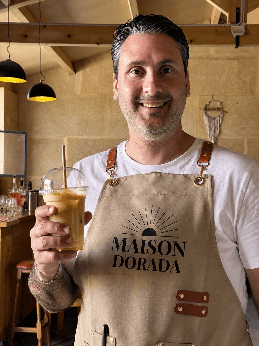 Maison Dorada founder holding an iced coffee.